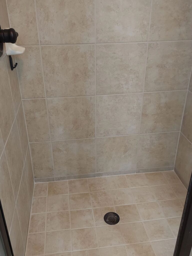 Shower after grout restoration with clean, uniform grout