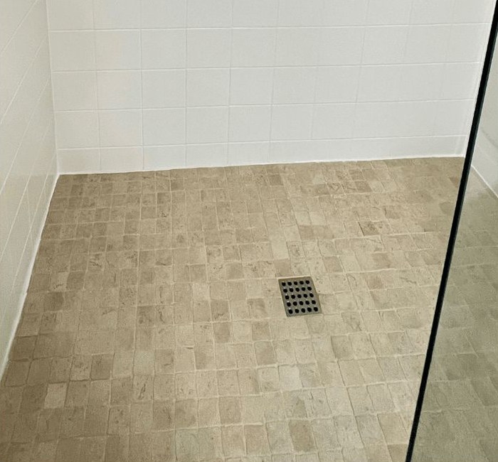 The same shower after restoration with clean, uniform grout